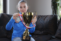 na fot. Lilly Jędrzejak prezentuje medale i puchar wywalczone na Halowych Mistrzostwach Polski U12