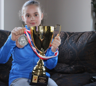 na fot. Lilly Jędrzejak prezentuje medale i puchar wywalczone na Halowych Mistrzostwach Polski U12